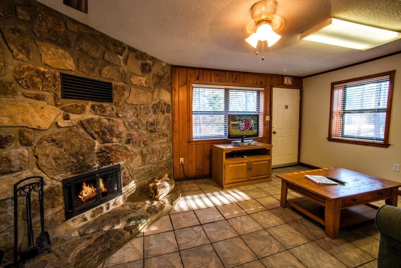 A view of the living room with a sitting area and fireplace at Cabin 3 at Crowley's Ridge State Park